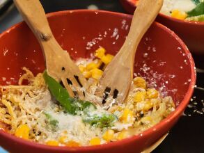 A cold summer salad served over pasta